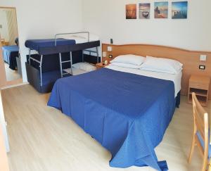 a bedroom with a blue bed and a desk at Hotel Mare Blu -- boutique in Pineto