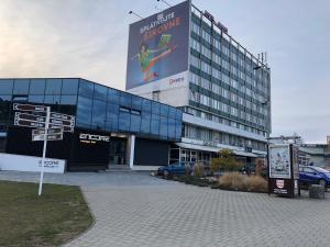 a large building with a large sign in front of it at Apartmán Lux Prešov in Prešov