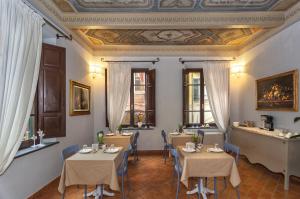a restaurant with tables and chairs in a room at Rinascimento Bed & Breakfast in Pisa