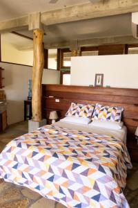 a bedroom with a large bed with a wooden headboard at Stunning Studio Suite - AC, Walk to Town and Beach in San Juan del Sur