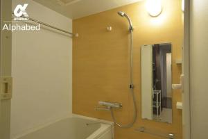 高松的住宿－Alphabed TakamatsuFurujinmachi 1002 / Vacation STAY 22011，浴室配有浴缸、淋浴和镜子