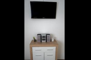 a table with a microwave and a tv on a wall at Apartment Vir with free private parking in Karlovac