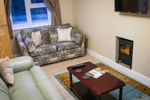 a living room with a couch and a fireplace at The Cottages Hamstall in Hamstall Ridware