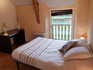 a bedroom with a large bed with a window at Gite et chambres de la porte du parc in Les Iffs