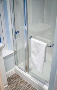 a bathroom with a shower with a white towel at The Cottages Hamstall in Hamstall Ridware