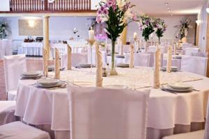 un comedor con mesas blancas y sillas blancas en Restauracja Hotel Kassandra, en Września