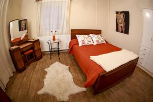 een slaapkamer met een bed met een oranje deken en een spiegel bij Forest Park Villa in Lemithou