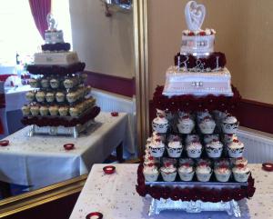a large wedding cake and cupcakes sitting next to a table at Somerton House Hotel in Lockerbie