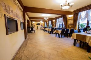 a dining room with tables and blue chairs at MAX International Hotel in Râşnov