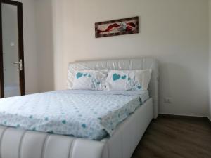 a bedroom with a white bed with blue sheets and pillows at Appartamenti MareBlu in Badesi