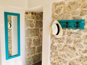 ein Badezimmer mit einer Steinmauer und einem blauen Spiegel in der Unterkunft APARTMAN Bervida Murter in Murter + 40 Fotos