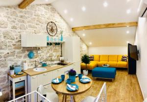 eine Küche und ein Wohnzimmer mit einem Tisch und einem gelben Sofa in der Unterkunft APARTMAN Bervida Murter in Murter