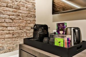 a black shelf with a coffee maker and books at Luxury Canal Suite De Heren in Amsterdam