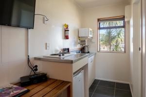 a small kitchen with a sink and a window at Foreshore Motor Lodge in Petone