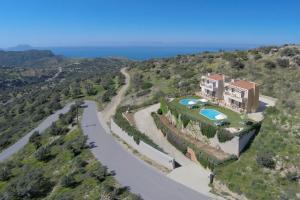 an aerial view of a house on a hill with a road at Triopetra Luxury Villas Fournou Lago in Triopetra