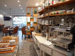 a restaurant with a counter with plates and tables at Hostal Gran Vía in Pinto