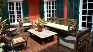 um pátio com 2 cadeiras, uma mesa e bancos em Maison de Campagne, Chambres D'Hôtes - Itaipava em Itaipava
