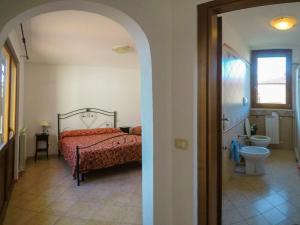 um quarto com uma cama e um banheiro com vaso sanitário em I Leoncini em Fonteblanda