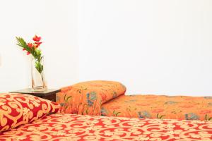 豐特博蘭達的住宿－I Leoncini，两张带枕头的床和一张桌子上的花瓶