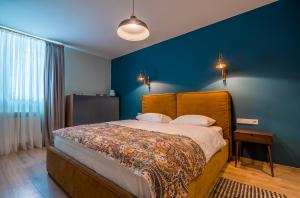 1 dormitorio con 1 cama con pared azul en CozyBaity in the very heart of Tbilisi, en Tiflis