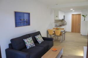 a living room with a couch and a kitchen at Apartamentos As Lagoas in O Grove