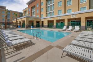 uma piscina com espreguiçadeiras e um edifício em Residence Inn by Marriott Ontario Rancho Cucamonga em Rancho Cucamonga
