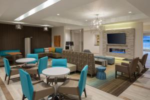 a lobby with tables and chairs and a living room at Residence Inn by Marriott Ontario Rancho Cucamonga in Rancho Cucamonga