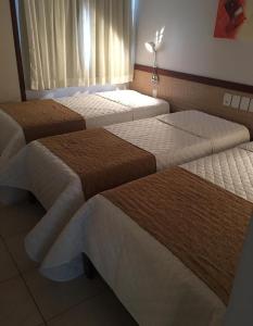 a room with three beds in a room at Portal da Princesa Hotel in Feira de Santana