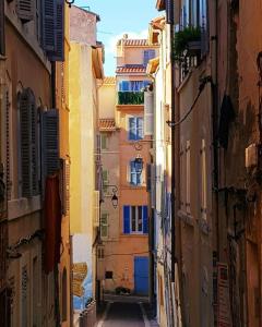 Une ruelle dans une vieille ville avec des bâtiments dans l'établissement Au coeur du Panier - Vieux Port, à Marseille