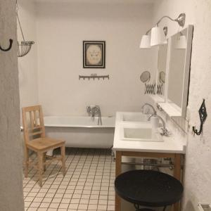 ein Badezimmer mit einer Badewanne, einem Waschbecken und einem Stuhl in der Unterkunft Herzlhof Rupp in Unterschwarza
