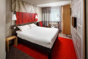 a hotel room with a white bed and a red carpet at ibis Glasgow City Centre – Sauchiehall St in Glasgow