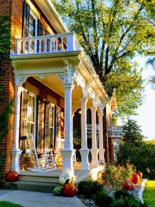 uma casa branca com um alpendre com um deque em Lamberson Guest House em Galena