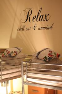 a bunk bed with pillows and a sign that reads relax chill out andwind at Hostel Centrum Sabot in Krakow