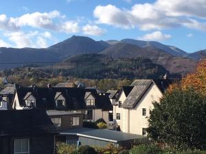 un grupo de casas con montañas en el fondo en Lincoln Guest House, en Keswick