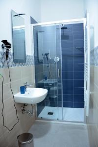 a bathroom with a sink and a glass shower at Mambo Suites in Bologna