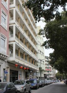 ulica z samochodami zaparkowanymi przed budynkiem w obiekcie Residencial Lord w Lizbonie