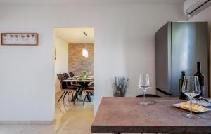 a kitchen and dining room with a table and two wine glasses at Family Apartment Ingrid in Pula