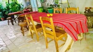 uma mesa de madeira com cadeiras e uma toalha de mesa com listras vermelhas em Hotel & Hostal Yaxkin Copan em Copán