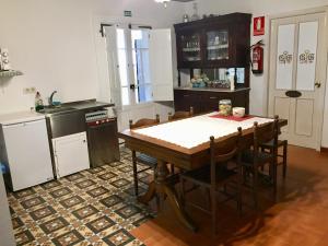 a kitchen with a table and chairs in a kitchen at Albergue-Hostel Casa da Gandara in Boimorto