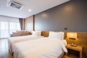 um quarto de hotel com duas camas e um sofá em Icon Park Hotel, Chiang Mai- SHA Extra Plus em Chiang Mai