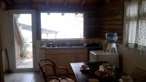 cocina con mesa, nevera y ventana en Anthar Andes en Potrerillos