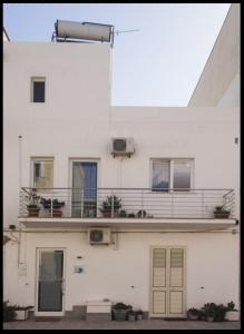 - un bâtiment blanc avec un balcon au-dessus dans l'établissement B&B CASA GILANIA LAMPEDUSA, à Lampedusa