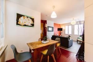 a living room with a dining room table and chairs at Appartement de l'Eléphant in Nantes