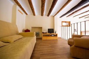 a living room with a couch and a tv at Apartamentos Aguilar in Alcañiz