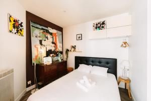 1 dormitorio con cama blanca y armario de madera en Appartement de l'Eléphant, en Nantes