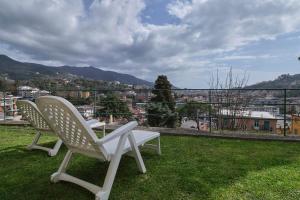 dos sillas blancas sentadas sobre un campo de hierba en Villino Adelaide, en Rapallo