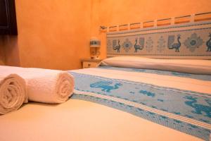 a hotel room with two beds with towels on them at B&B Sa Lumenaria "da Raimonda" in Sorgono