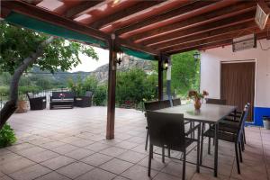 a patio with a table and chairs under a pergola at ALCALA DEL JUCAR, Casa rural Rio Tranquilo 1 -Piscina privada- in Tolosa