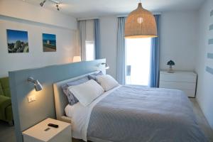 1 dormitorio con 1 cama grande y luz colgante en Malù Bed&Breakfast, en Polignano a Mare