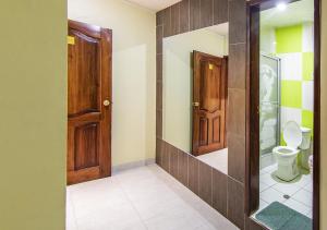baño con aseo y puertas de madera en Hostal Oro Orense, en Quito